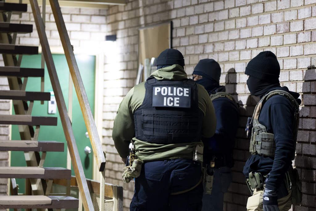 U.S. Immigration and Customs Enforcement officers wait to detain a person in Silver Spring, Maryland earlier this year. (Alex Brandon/AP)