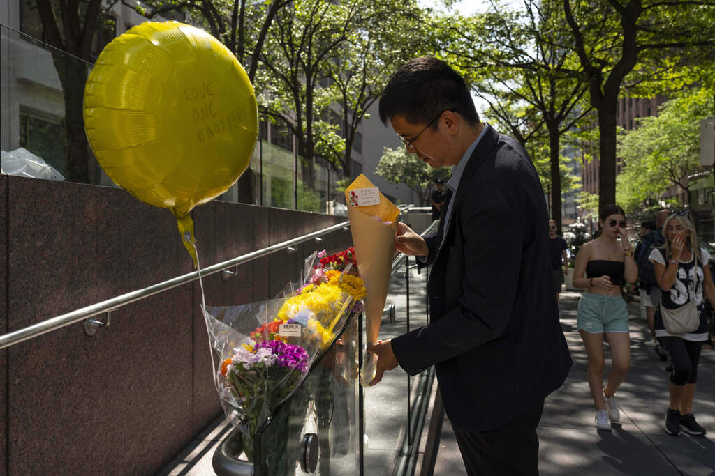 A person leaves flowers at a make shift memorial outside scene of Monday's deadly shooting in New York. (uki Iwamura/AP)