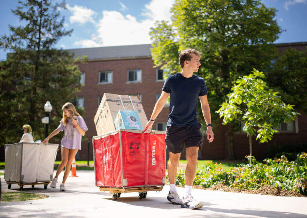 A student moves into his college dorm with the help of his little sister. (Jeff Wheeler/Star Tribune via Getty Images)
