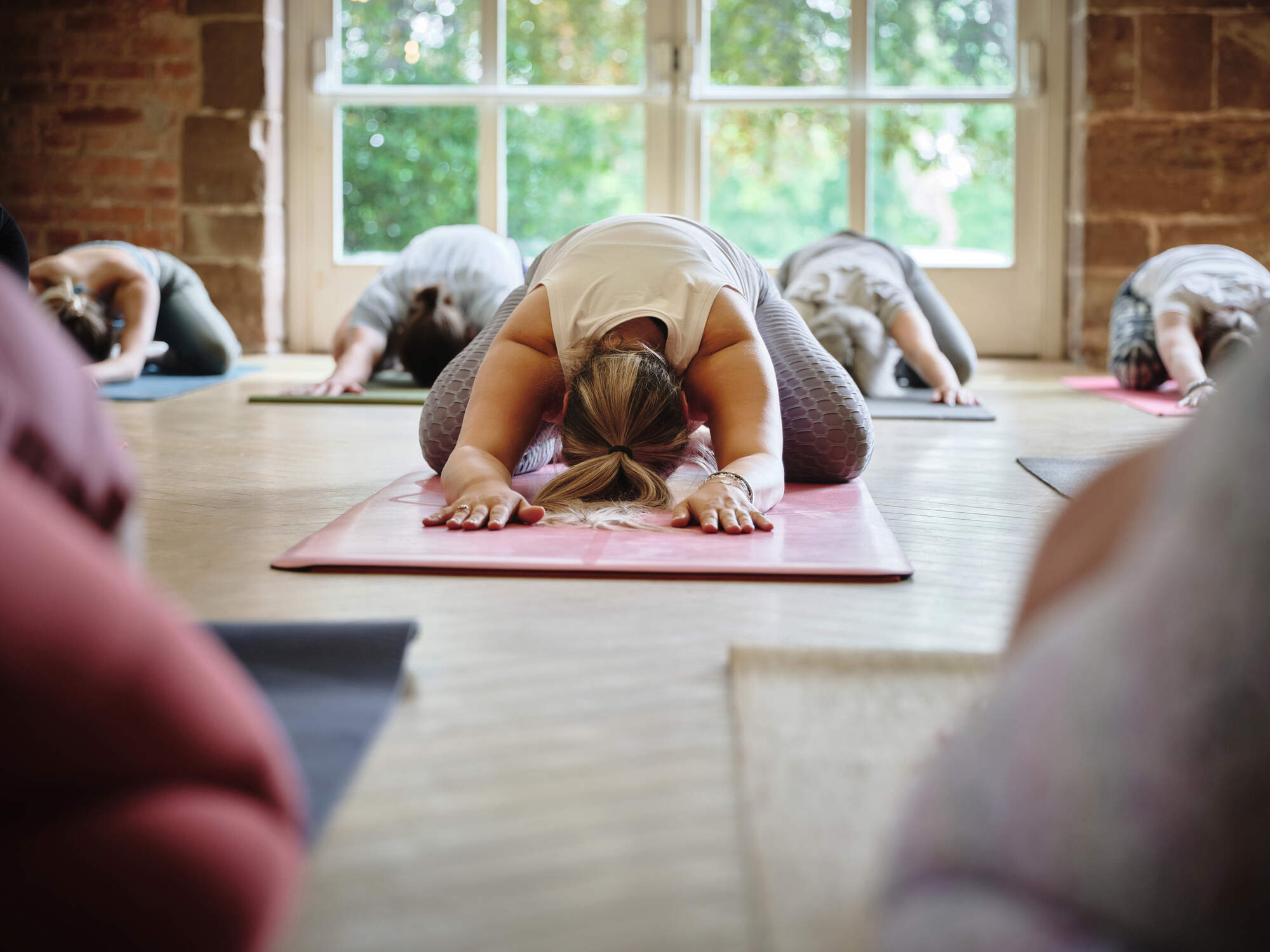 People in child's pose in a yoga class (Getty Images)