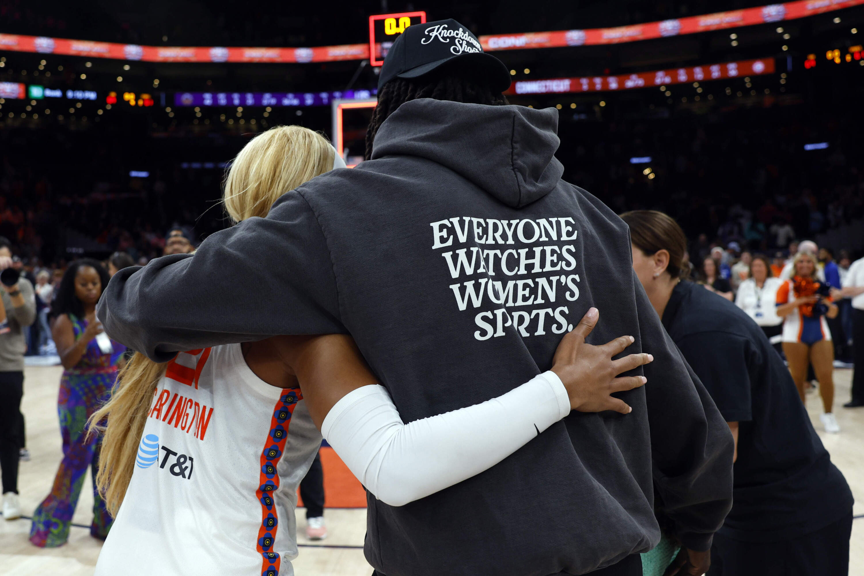 Boston Celtics guard Jrue Holiday hugs Connecticut Sun guard DiJonai Carrington during the WNBA's first game at TD Garden last August.