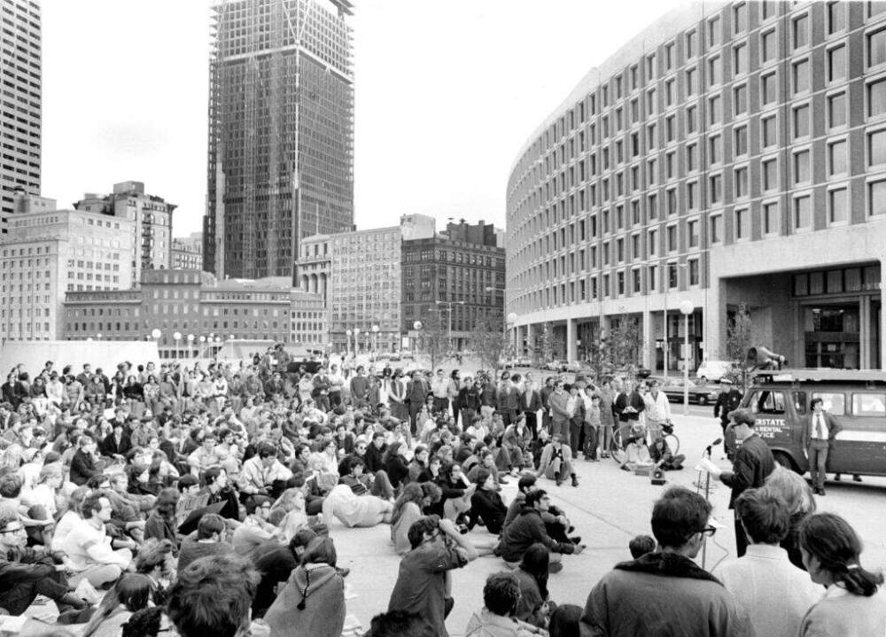John Pennington of Students for a Democratic Society makes concluding remarks at the podium following a protest opposing the Vietnam War, college administrators and high rents in Cambridge outside the Federal Building in Boston on Oct. 4, 1969. (Photo by Frank Wing/The Boston Globe via Getty Images)