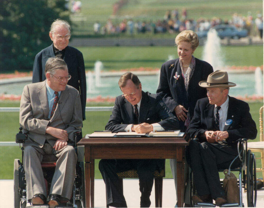 George Bush signs the Americans with Disabilities Act in Washington, D.D., on July 26, 1990. (Fotosearch/Getty Images).