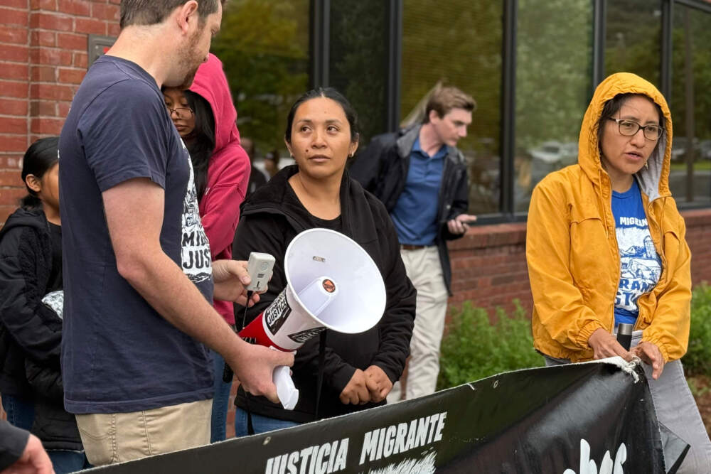 Wuendy Bernardo, foreground center, a migrant dairy farmworker at risk of deportation, is greeted by Migrant Justice staff member Will Lambek, left, outside a U.S. Immigration and Customs Enforcement office in St. Albans, Vt. (Amanda Swinhart/AP)