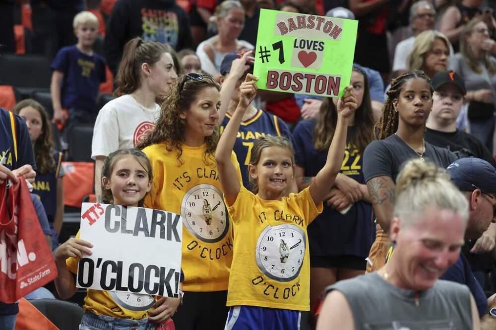 Fans hold signs before a WNBA basketball game between the Connecticut Sun and the Indiana Fever at TD Garden. (Michael Dwyer/AP)