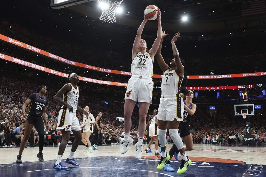 Indiana Fever's Caitlin Clark (22) grabs a rebound beside teammate Aliyah Boston (7) during the second half of a WNBA basketball game against the Connecticut Sun, Tuesday, July 15, 2025, in Boston. (Michael Dwyer/AP)