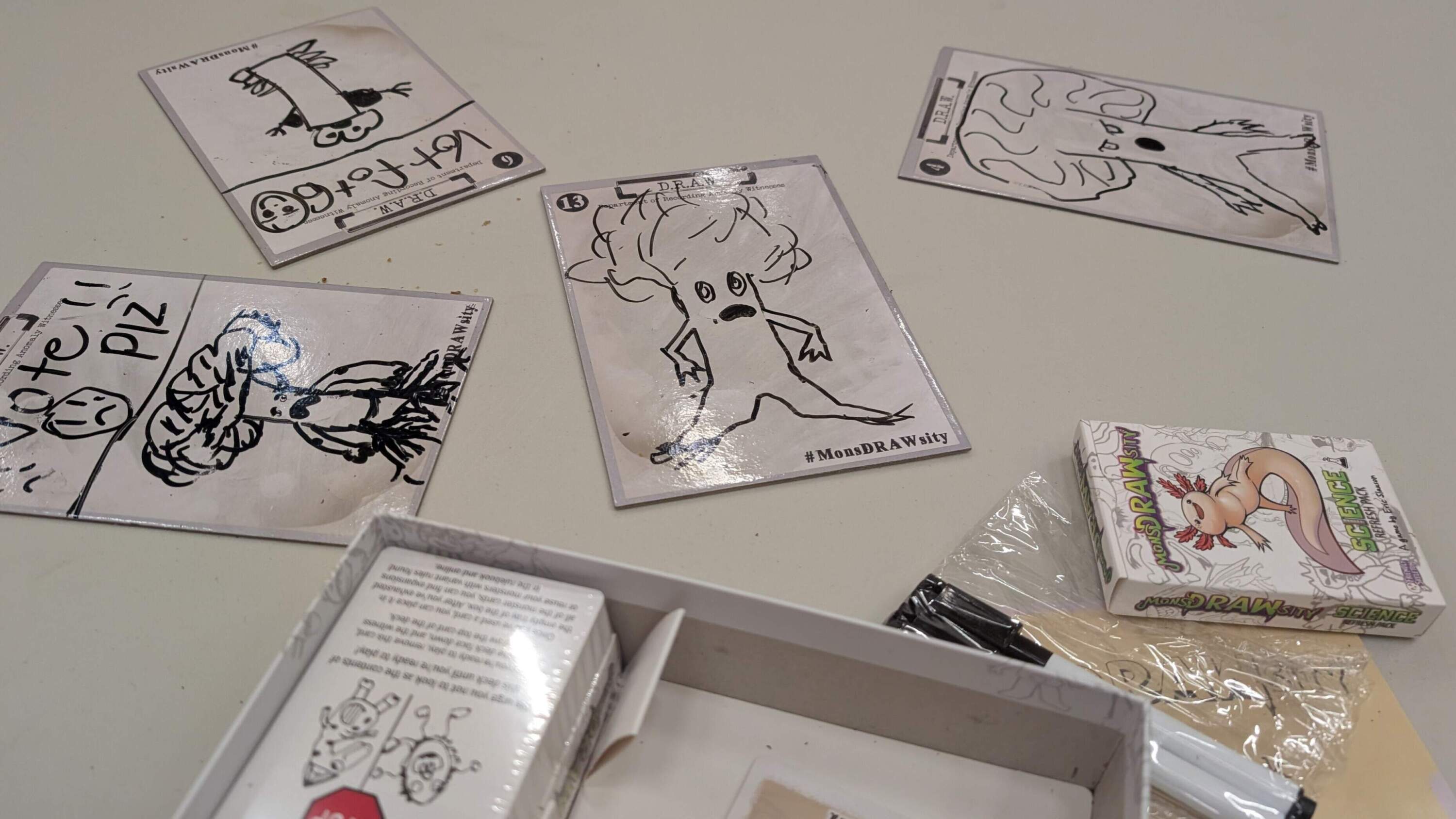 Examples of &quot;monsDRAWsity&quot; illustrations (and clear attempts to manipulate the vote) from a game with players aged six and up. (Photo by James Mastromarino, Courtesy of Friendly Skeleton)