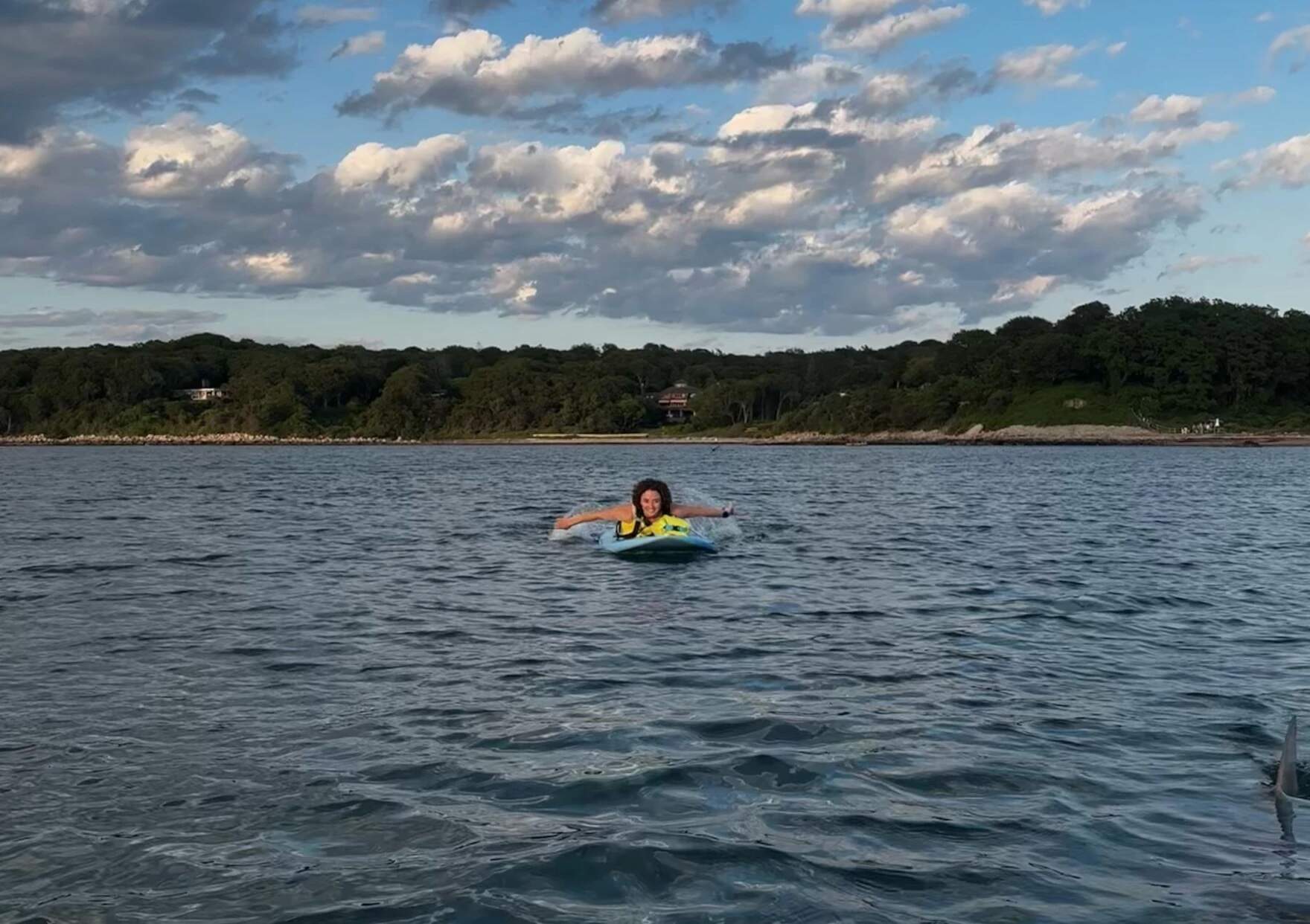 Margaret Bowles was paddleboarding off Stoney Beach in Woods Hole with her friend Maddie Cronin when she noticed a concerning dorsal fin poke out of the water. The fin is visible in the bottom right corner of the photo. (Courtesy of Maddie Cronin via CAI)