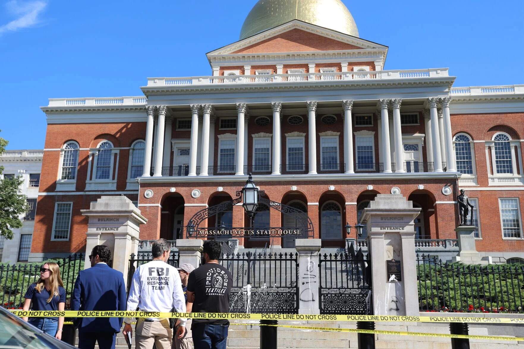 Law enforcement gather around the State House gates on July 23, 2025 after white paint was splattered on the front gates. Ella Adams / SHNS