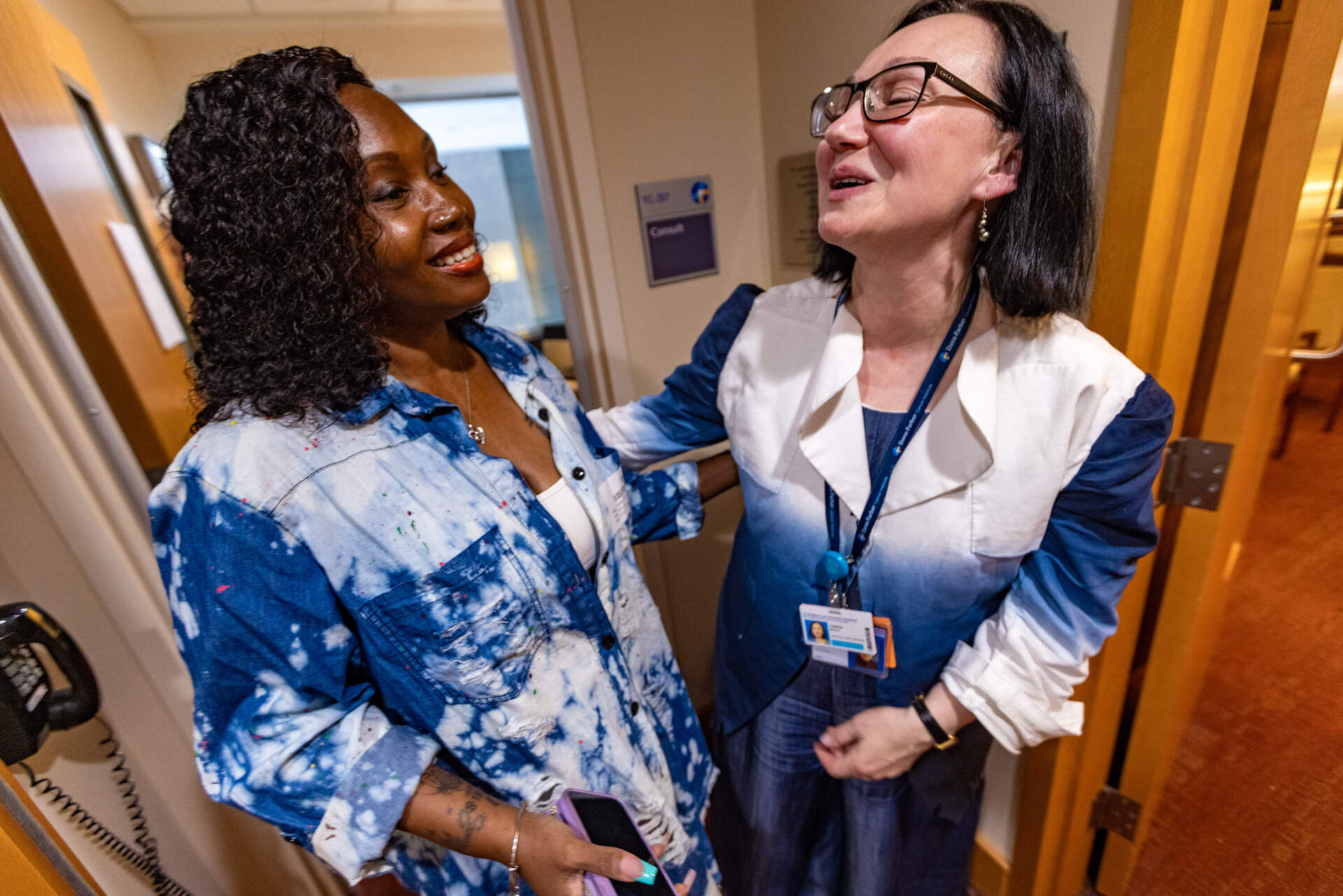 Dana Farber hospital chaplain Larisa Waya, right, greets Charisse Pinkney outside her office. (Jesse Costa/WBUR)