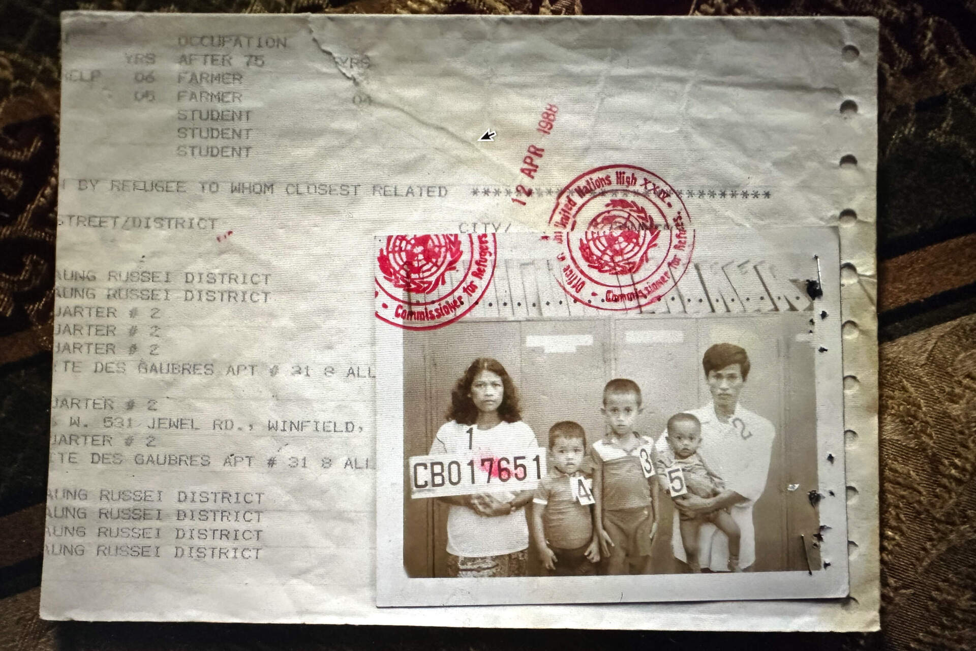 A document created when Theravy Chan and Boeun Thoeun, holding Samath, prepared to leave Thailand in the late 1980s. (Jesse Costa/WBUR)