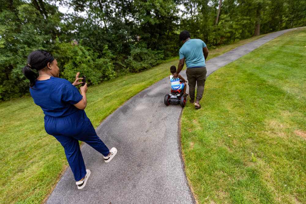 Ivanne takes a photo of Jacques and his son. (Jesse Costa/Wbur)