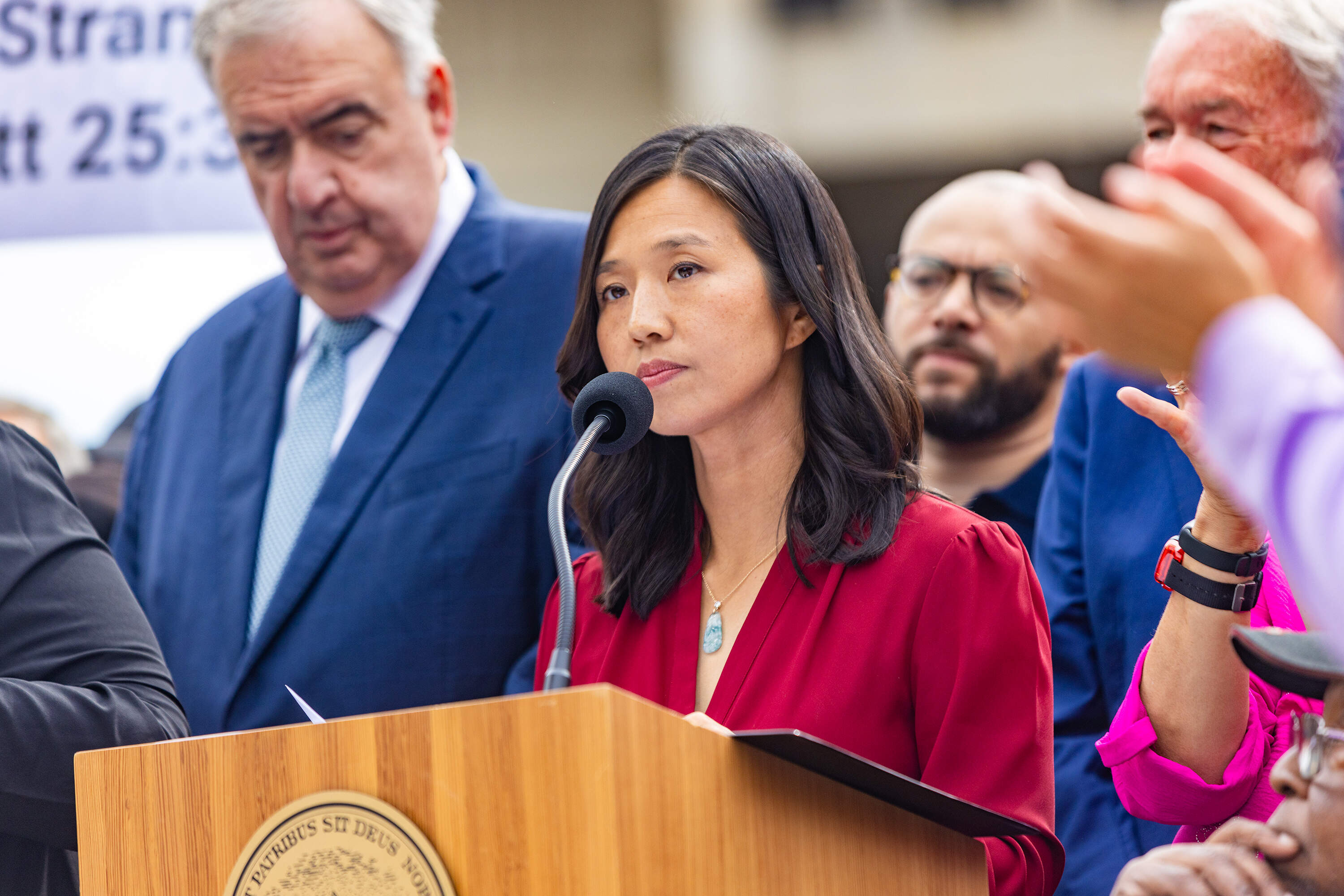 Boston Mayor Michelle Wu, joined by community members and elected officials, responds to the Department of Justice during a press conference at City Hall Plaza on Tuesday. (Jesse Costa/WBUR)