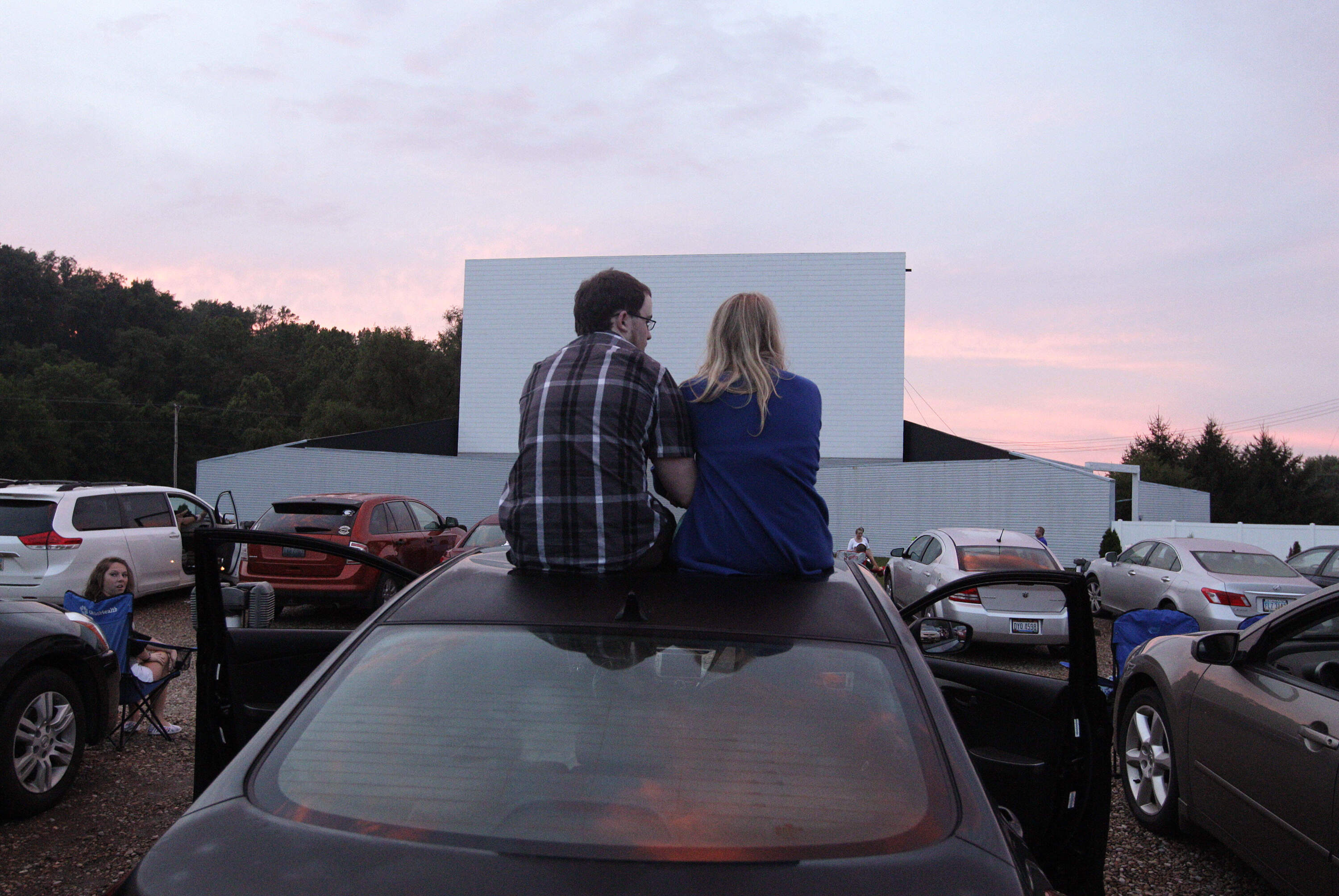 Alex Lockhart, left, and Mikayla Green, watch the sunset on top of a car. (Jay LaPrete/AP)