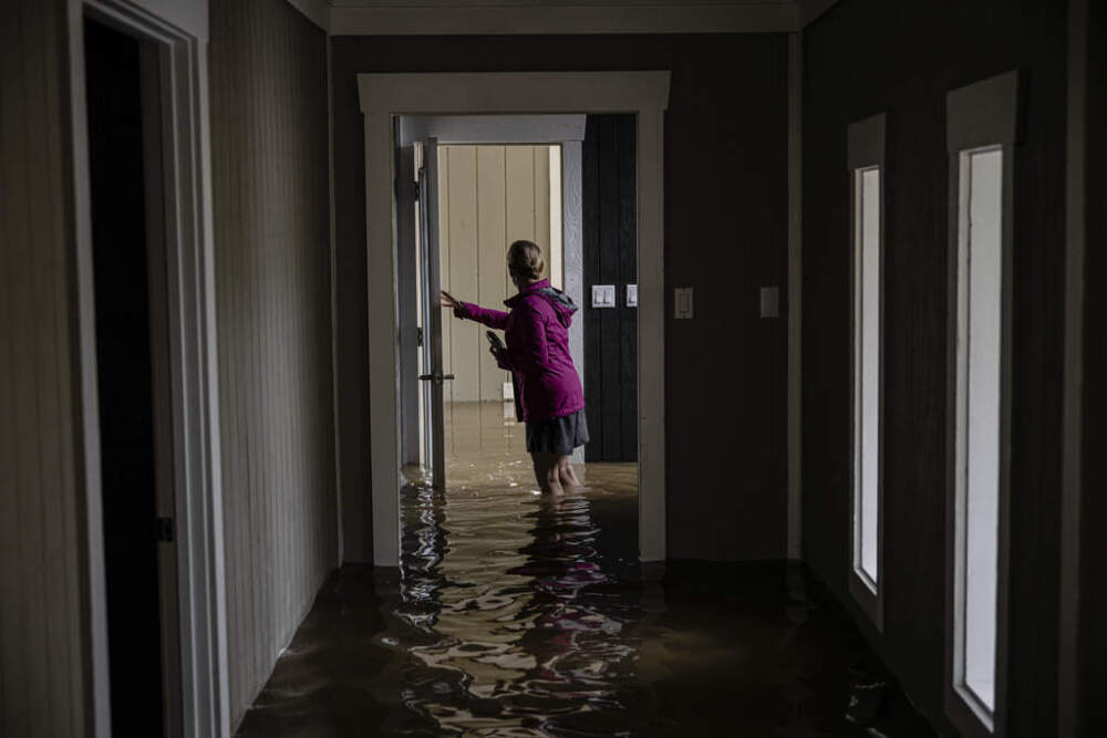 Carole Smith walks through her flooded home in Frankfort, Kentucky, in April 5. (Jon Cherry/AP)
