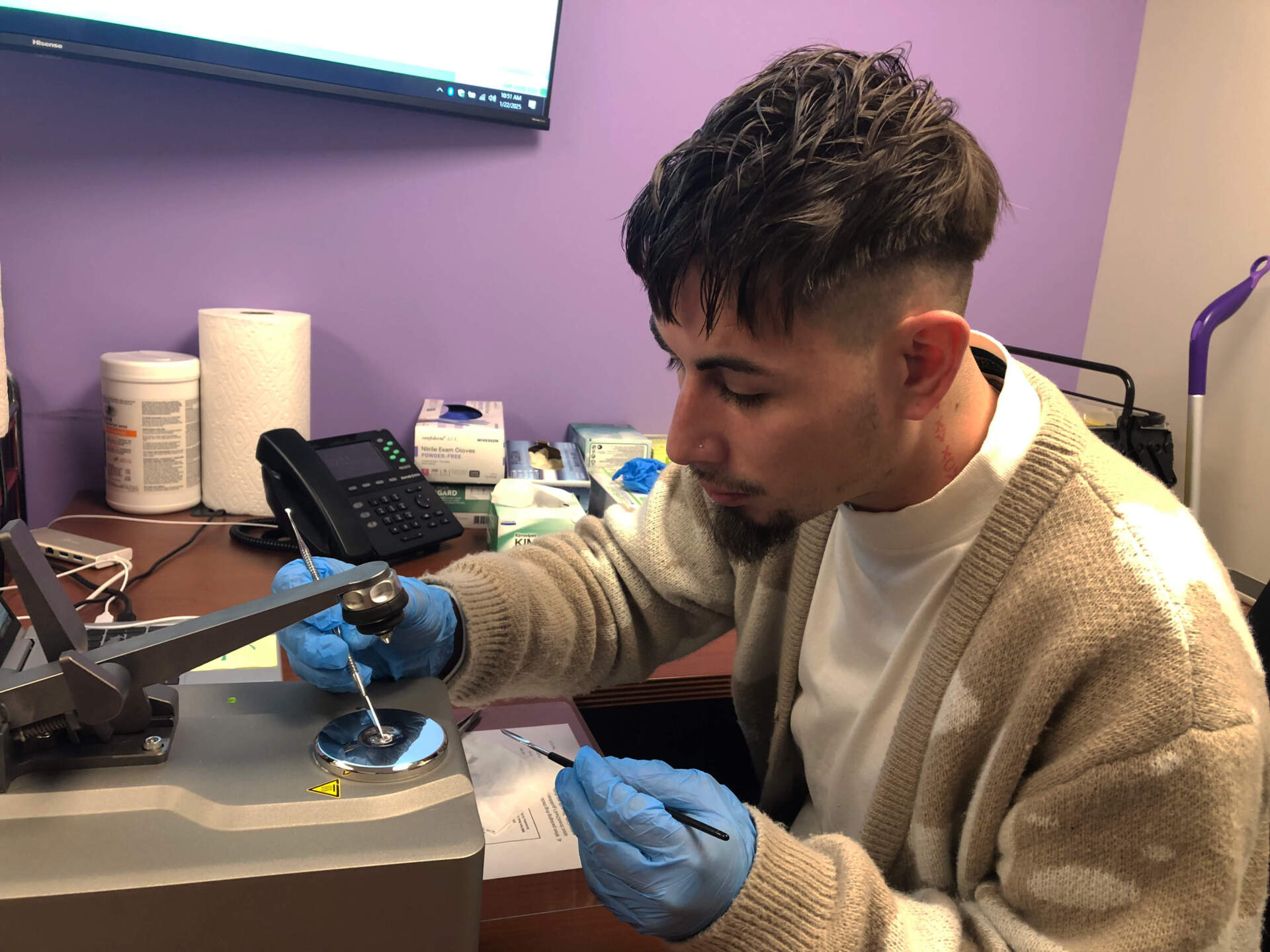 Kevin Davila with AIDS Project Worcester tests fragments of an illegal pill. He'll share results with the client who bought the pill and a street drug checking website.(Martha Bebinger/WBUR)