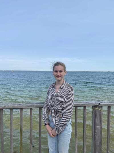 Provincetown IB Schools student Bella Wirthwein stands by the beach in front of her old house, which was floated across the inlet, June 2, 2025. (Samantha Watson/KYUK)