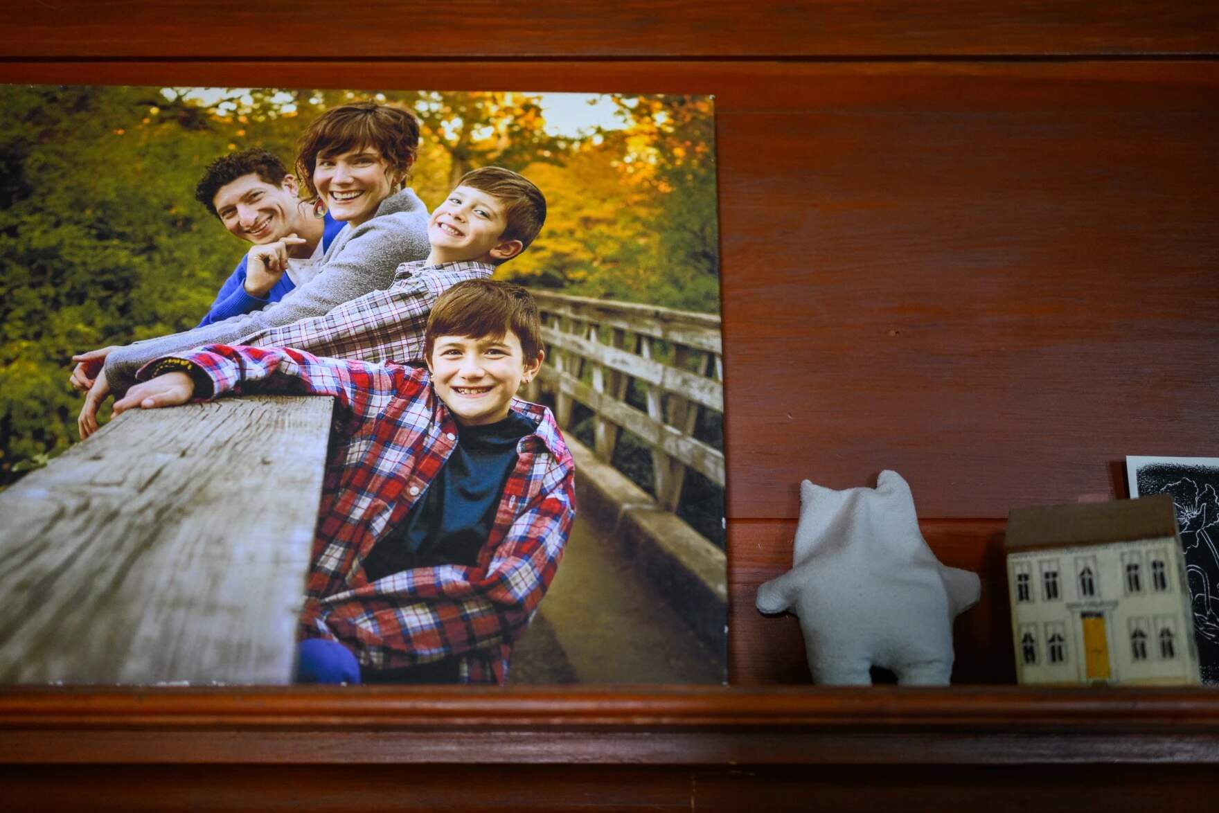 A photograph of the Heumann’s rests on a shelf on their home depicting the family from a little more than ten years ago when Daniel was 8 and, according to his father Micah, before medically transitioning but, “Out to the world as Daniel.” (Mark Mirko/Connecticut Public)