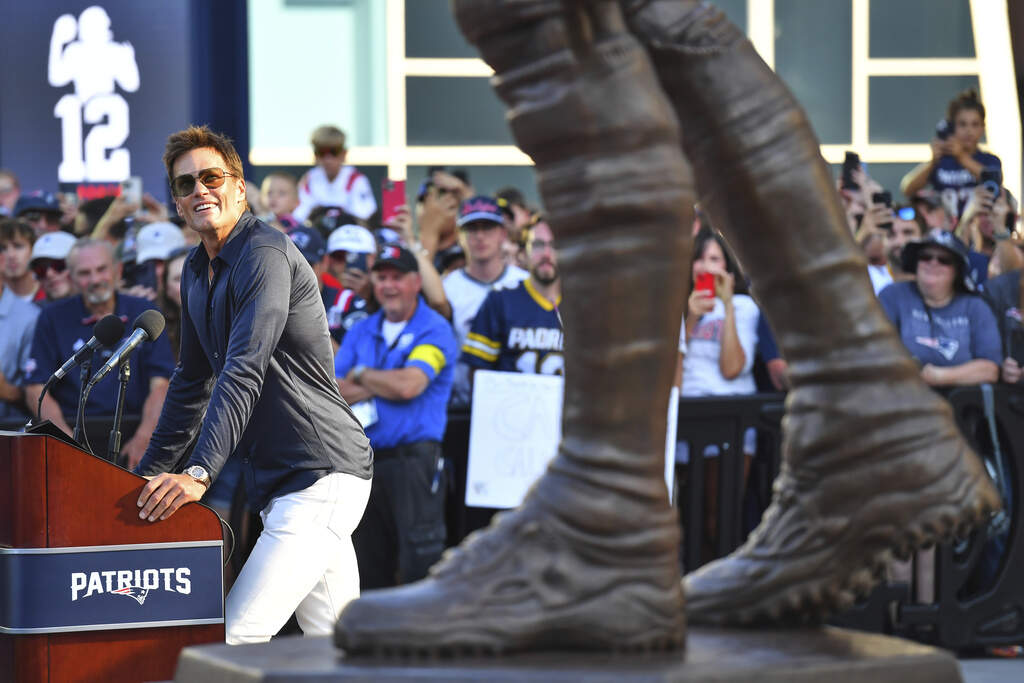 Former New England Patriots quarterback Tom Brady, left, looks at a bronze statue of himself at Patriot Place Plaza. (Charles Krupa/AP)