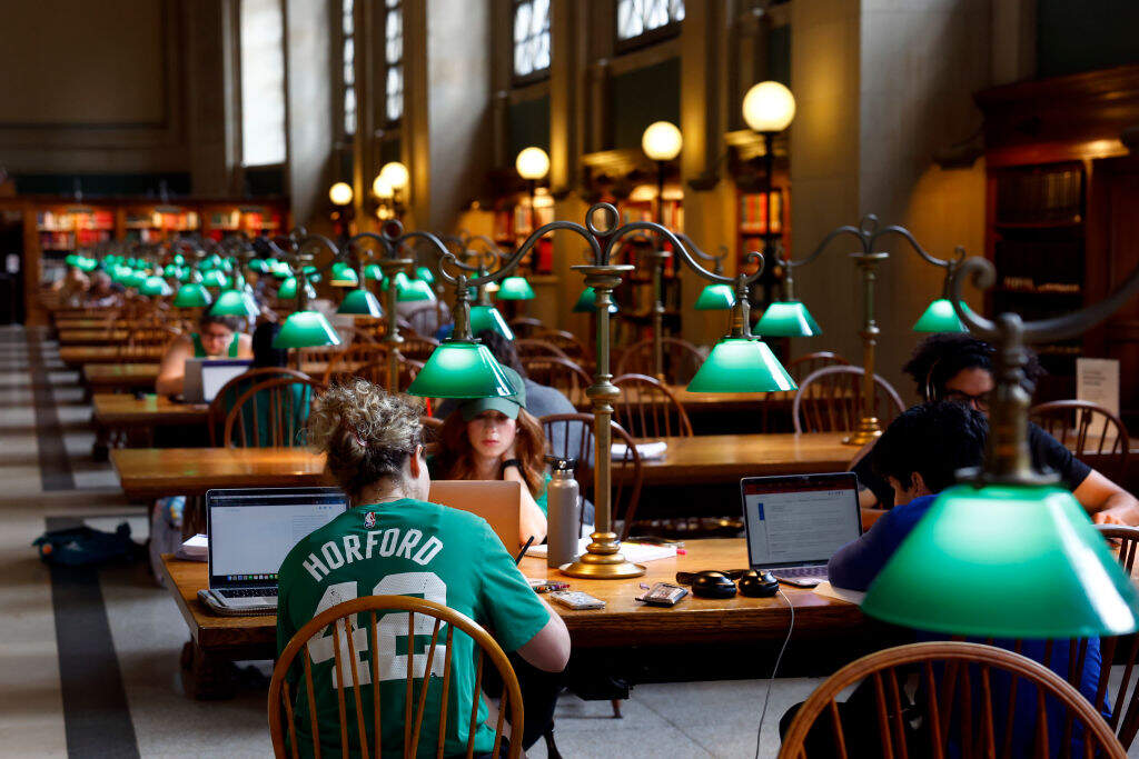 Boston Celtics fans in the Boston Public Library before the duck boat parade to celebrate the 18th Boston Celtics NBA championship on June 21, 2024. (Danielle Parhizkaran/The Boston Globe via Getty Images)