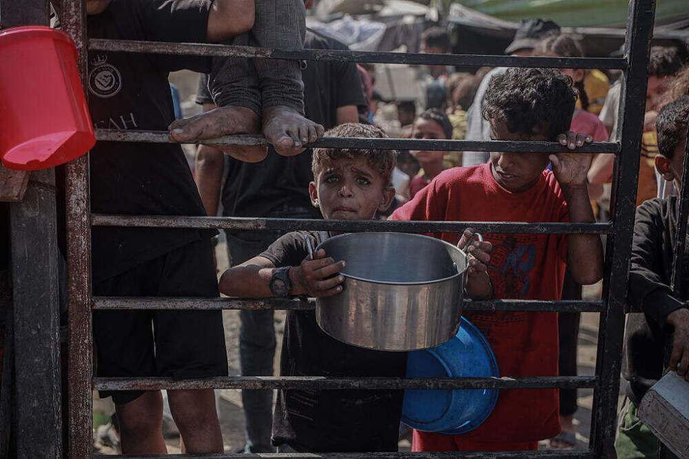 Crowds form as Palestinians receive food distributed by a charity amid the ongoing Israeli blockade and attacks on Gaza, on August 3, 2025. As Gaza teeters on the brink of famine under the ongoing Israeli blockade, Palestinians continue to face difficulties accessing basic supplies. (Abdalhkem Abu Riash/Anadolu via Getty Images)