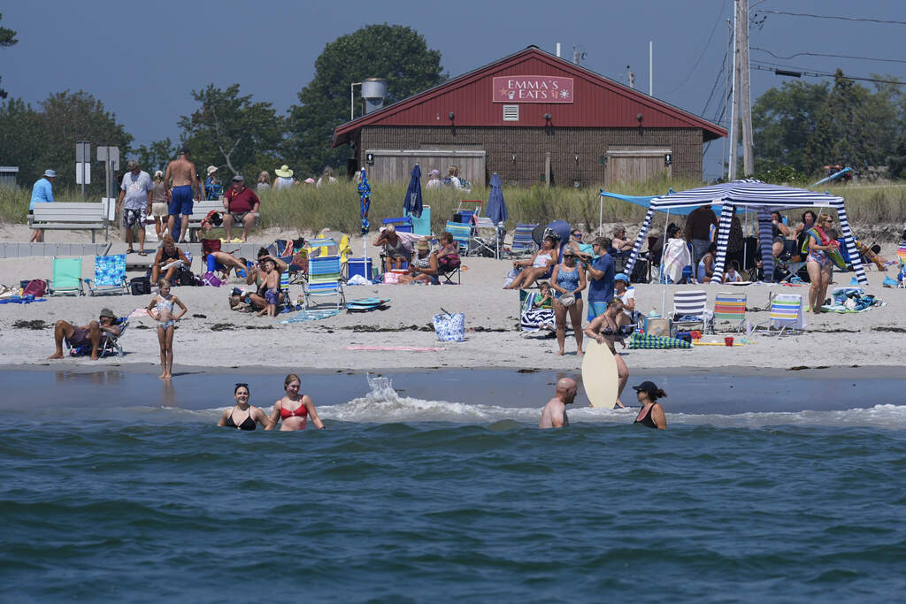 Visitors enjoy the summer weather not far from recent sightings of white sharks, Wednesday, Aug. 13, 2025, in Scarborough, Maine. (Robert F. Bukaty/AP)