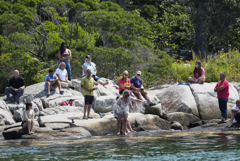 Kim Ware, of Somerville, Mass., spreads the ashes of her sister, Sunshine Stewart, on High Island during a memorial service, Sunday, Aug. 10, 2025. (Robert F. Bukaty/AP)