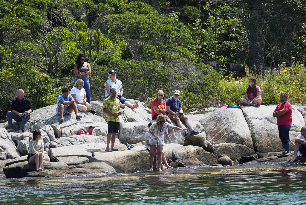 Kim Ware, of Somerville, Mass., spreads the ashes of her sister, Sunshine Stewart, on High Island during a memorial service, Sunday, Aug. 10, 2025. (Robert F. Bukaty/AP)