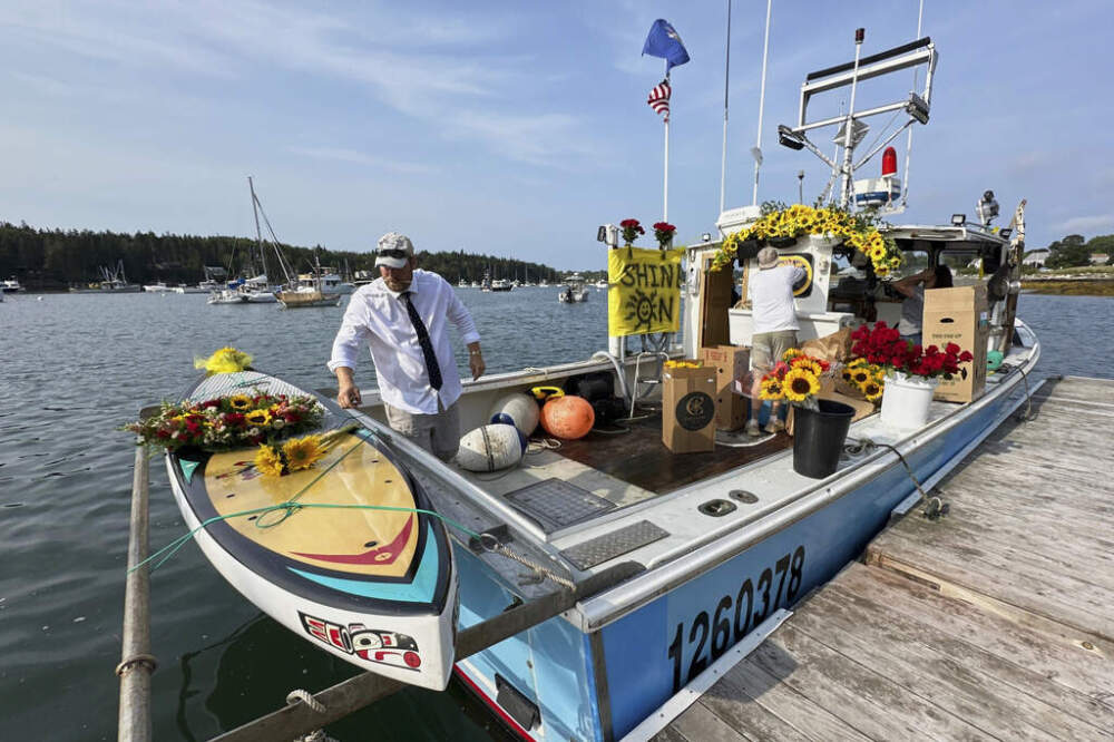 Lobsterman Josh Hupper adds flowers to Sunshine Stewart's paddleboard prior to a memorial service, Sunday, Aug. 10, 2025, in St. George, Maine. (Robert F. Bukaty/AP)