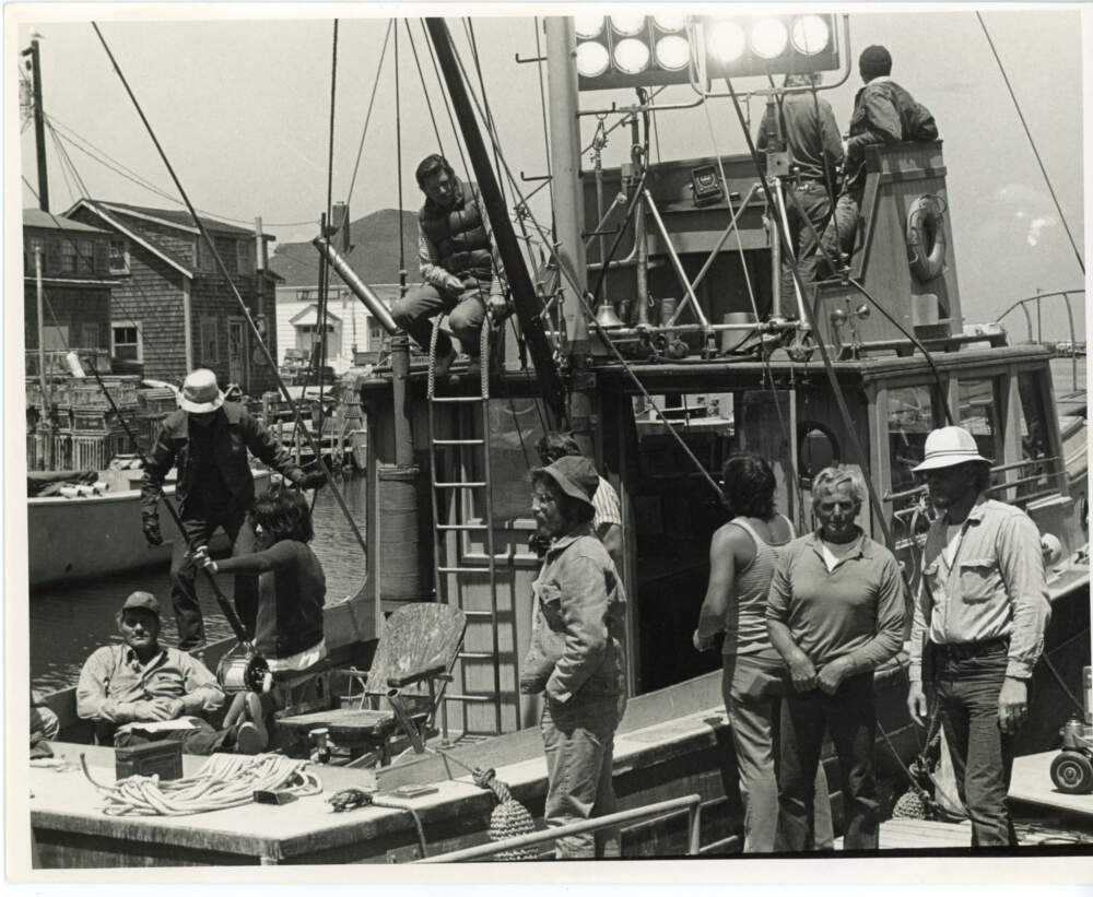 The film crew works on the Orca, Quint’s boat in the film. Robert Shaw, who plays Quint, gazes at the camera from the deck of the boat. Richard Dreyfuss, who plays scientist Matt Hooper, stands in the center of the photo. (Courtesy of Edith Blake/Martha's Vineyard Museum)