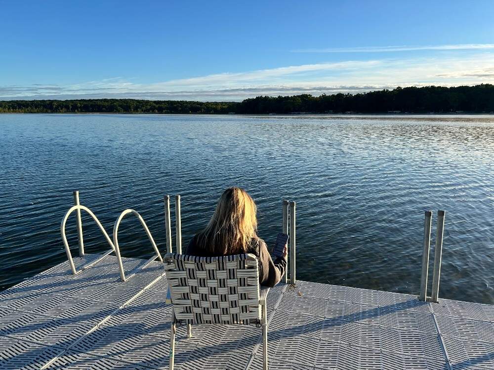 The author, listening for birds on a dock by her family's home in Michigan. (Courtesy Laura McTaggart)