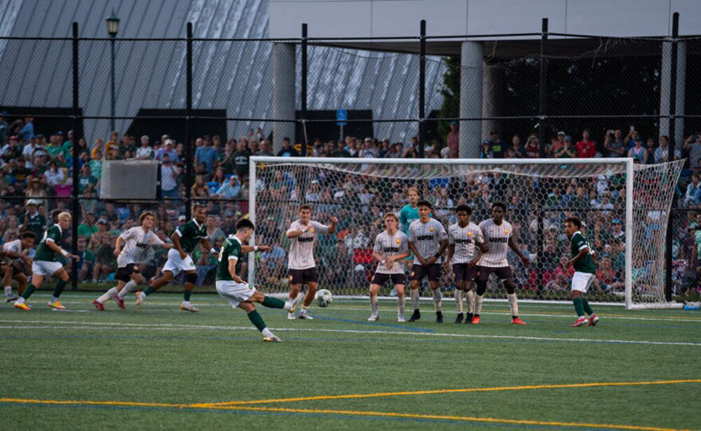 A Vermont Green player takes a free kick during the USL League Two national championship. (Brian Stevenson/Vermont Public)