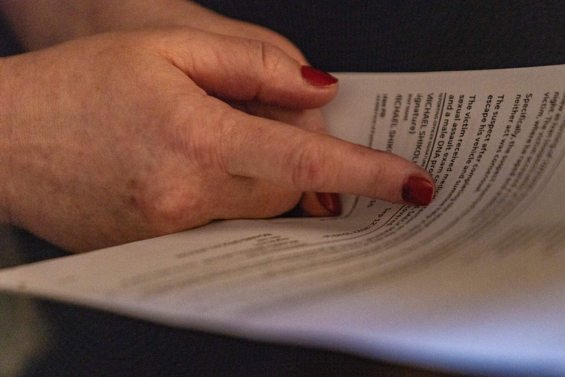 Louise reads a Suffolk County court docket document about her case for the first time. (Jesse Costa/WBUR)