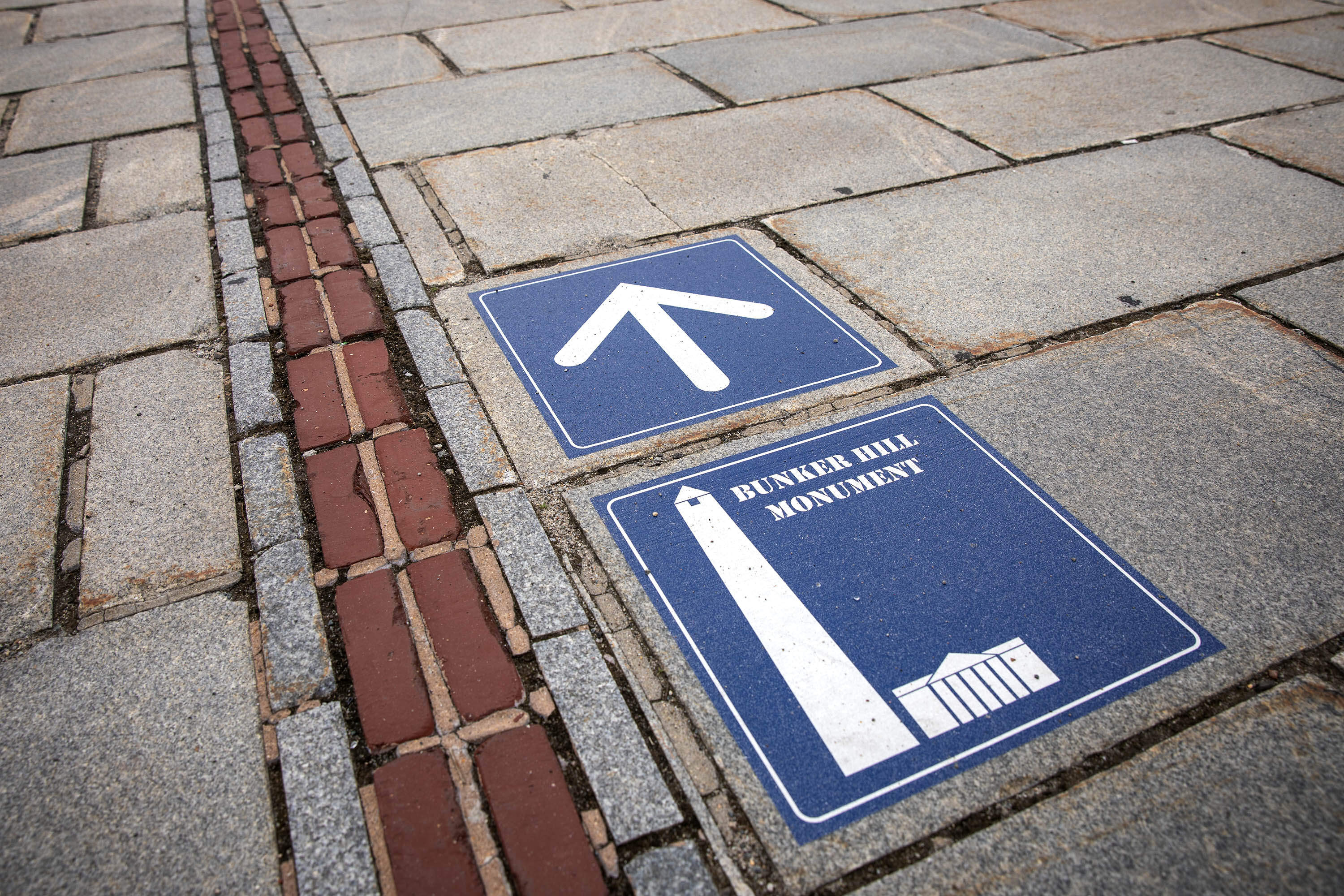 A sign by the Charlestown Navy Yard points the way along the Freedom Trail in the direction of Bunker Hill.