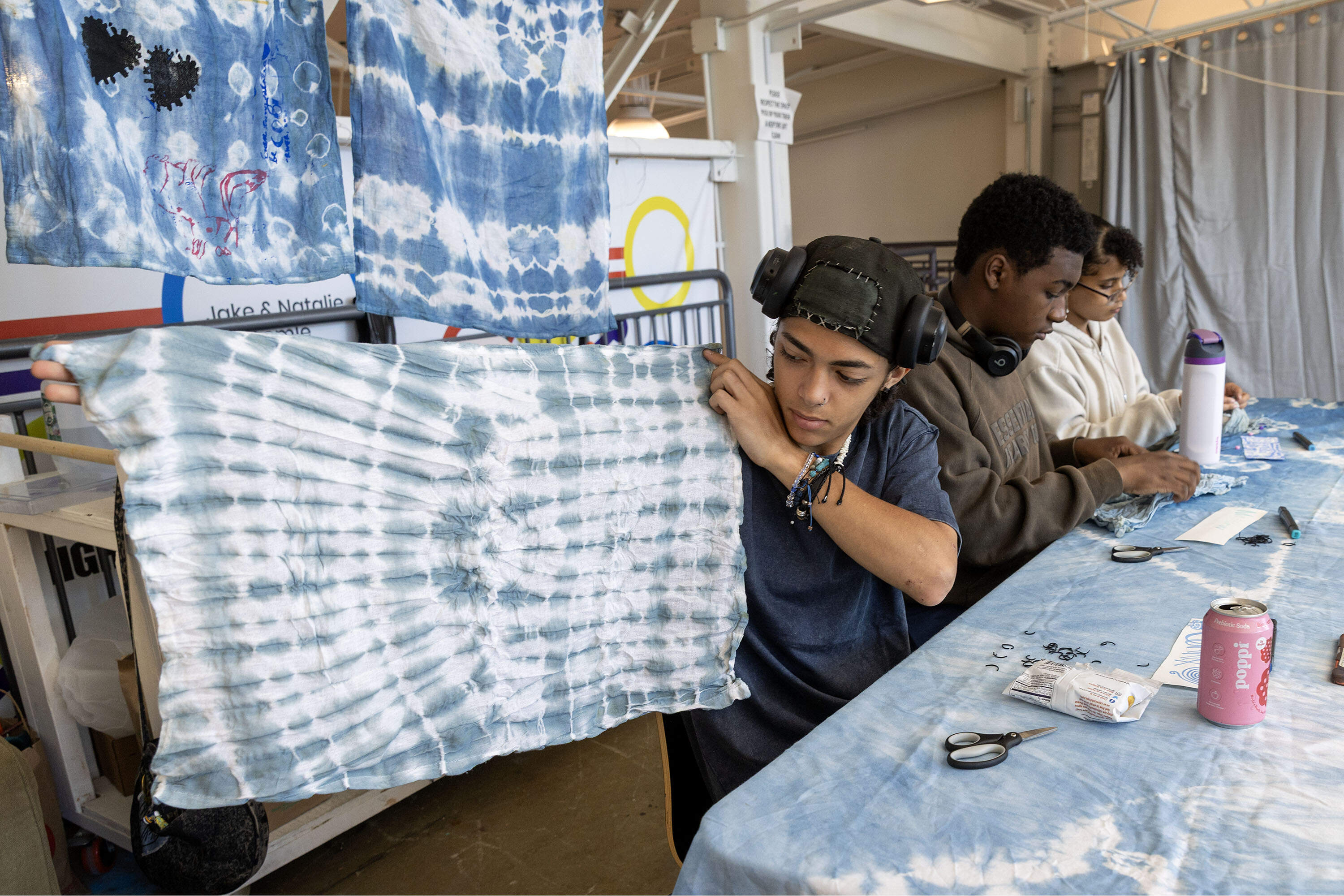 Teen artist Lennix Pabon-Velez looks at his work in a class exploring indigo dye and cloth. (Robin Lubbock/WBUR)