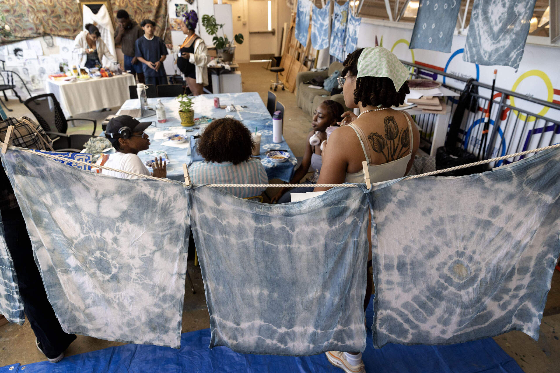 White squares of fabric dyed with indigo hang on a line in artist Tanya Nixon-Silberg class at Artists for Humanity, in Boston, Mass. (Robin lubbock / wbur)