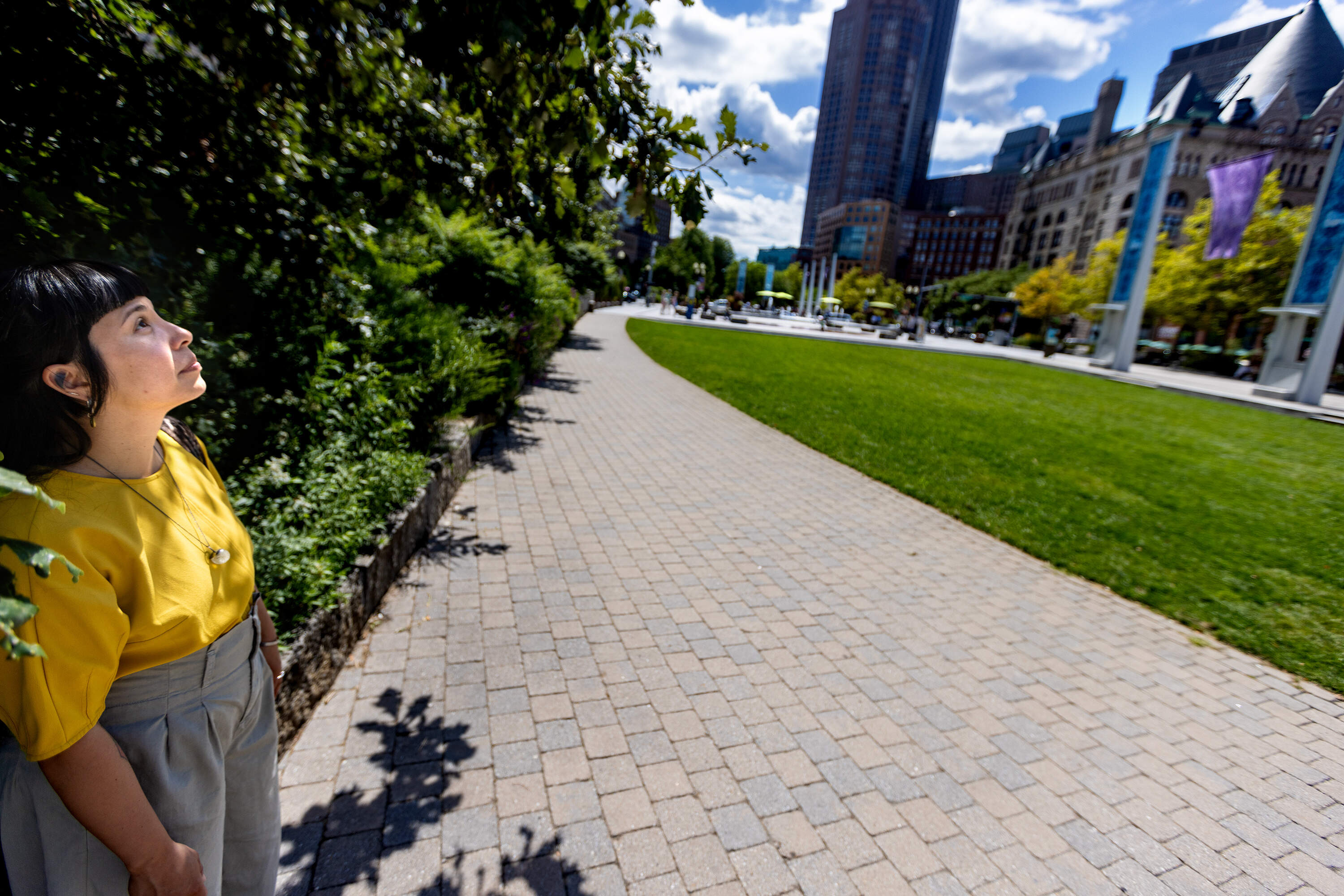 Artist Lani Asunción gazes at the "Binakol Blessing" light blades and flags of their art installation at the Rose Kennedy Greenway. (Jesse Costa/WBUR)