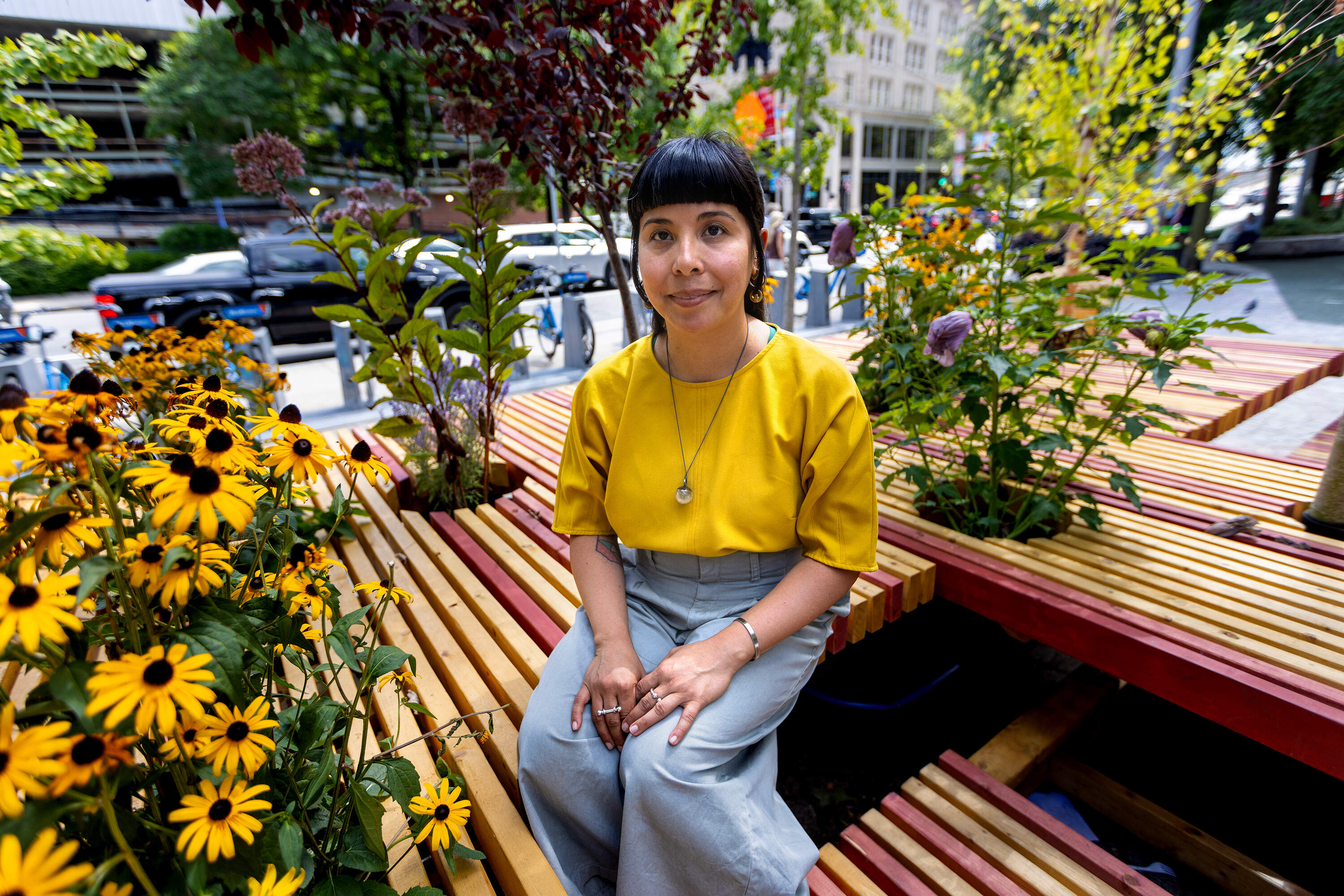 Lani Asuncion sits at "PlanTable," an art installation at Chin Park in Chinatown. (Jesse Costa/WBUR)