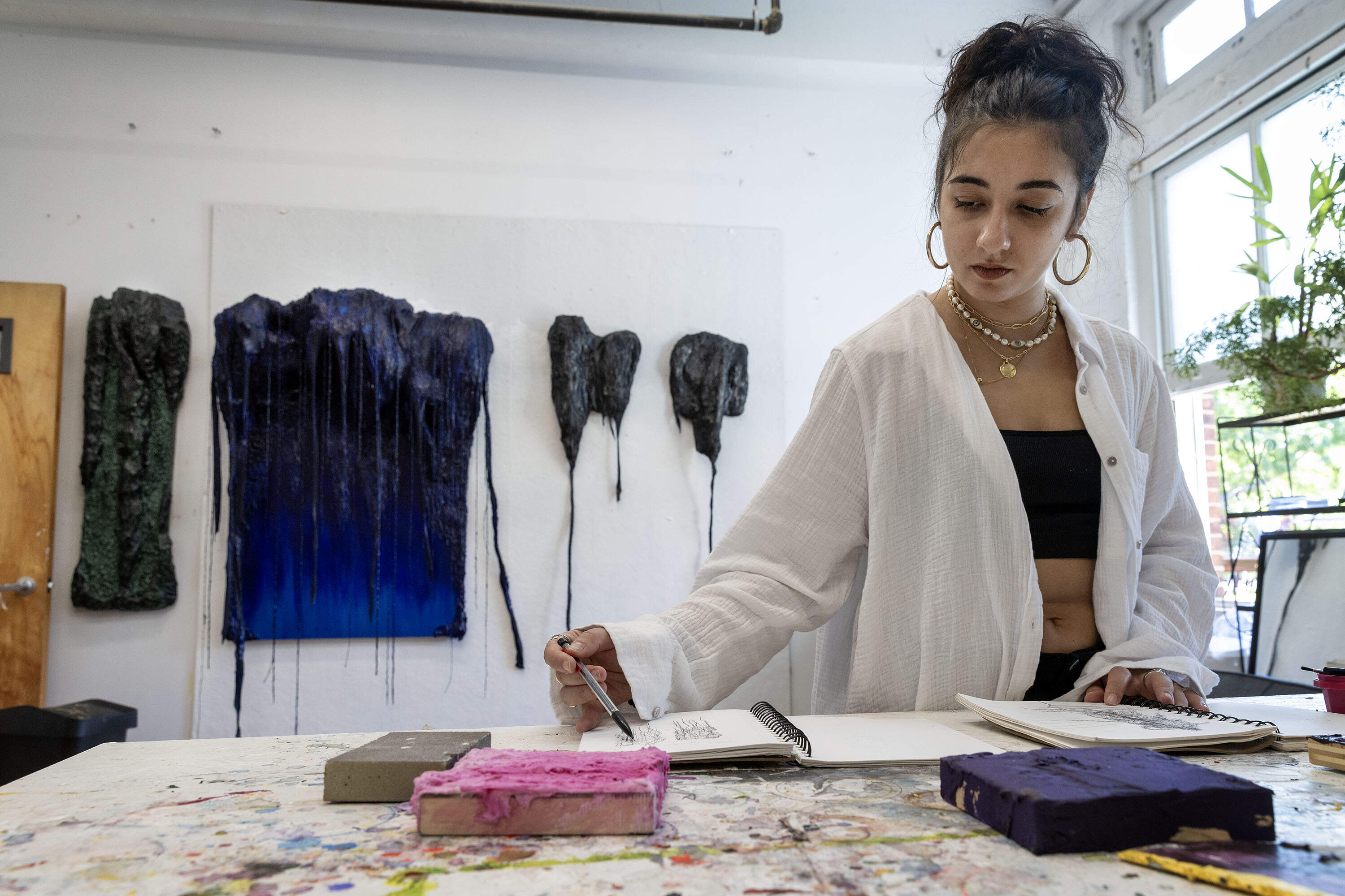 Artist Jo Nanajian sketches in her studio in Somerville, Mass. (Robin Lubbock/WBUR)