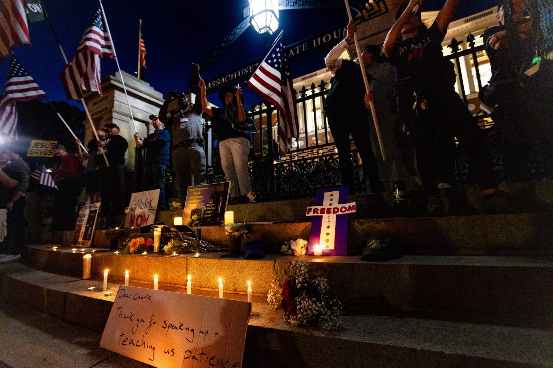 Vigil attendees gather in front of the State House during the vigil for Charlie Kirk. (Jesse Costa/WBUR)