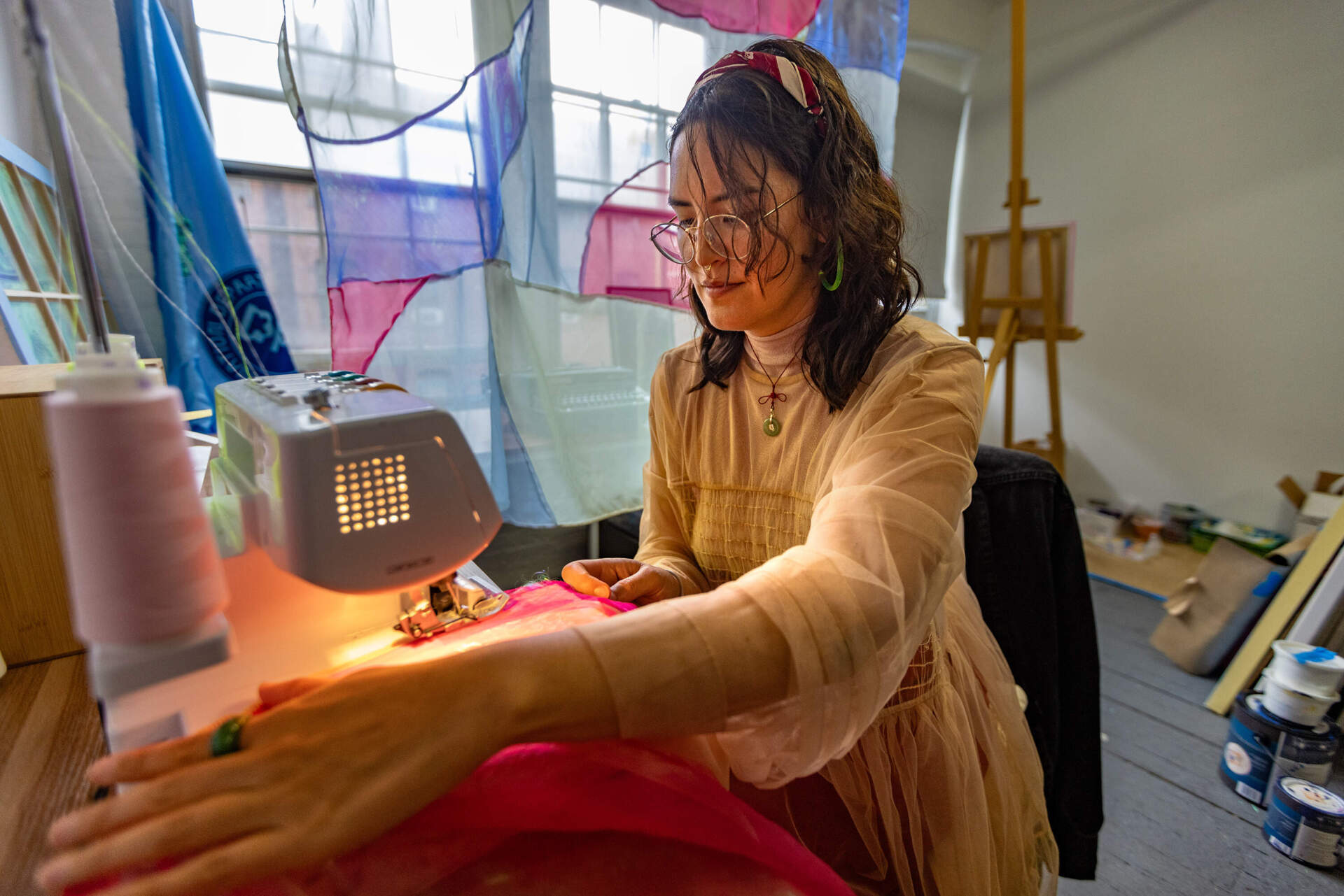 Artist crystal bi works on a panel on a sewing machine for an upcoming art installation. (Jesse Costa/WBUR)