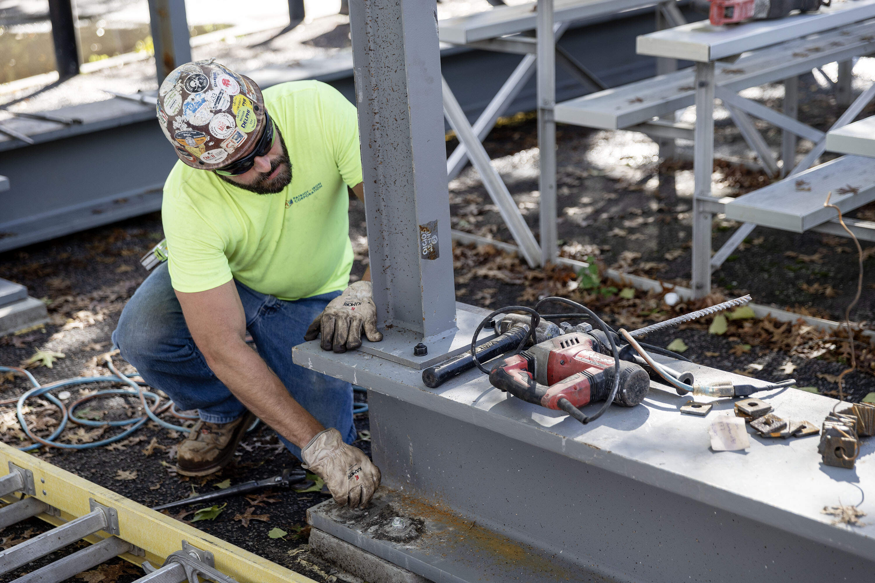 An ironworker works on the anchor bolts of a huge recycled steel beam that forms part of the structure's base. (Robin Lubbock/WBUR)