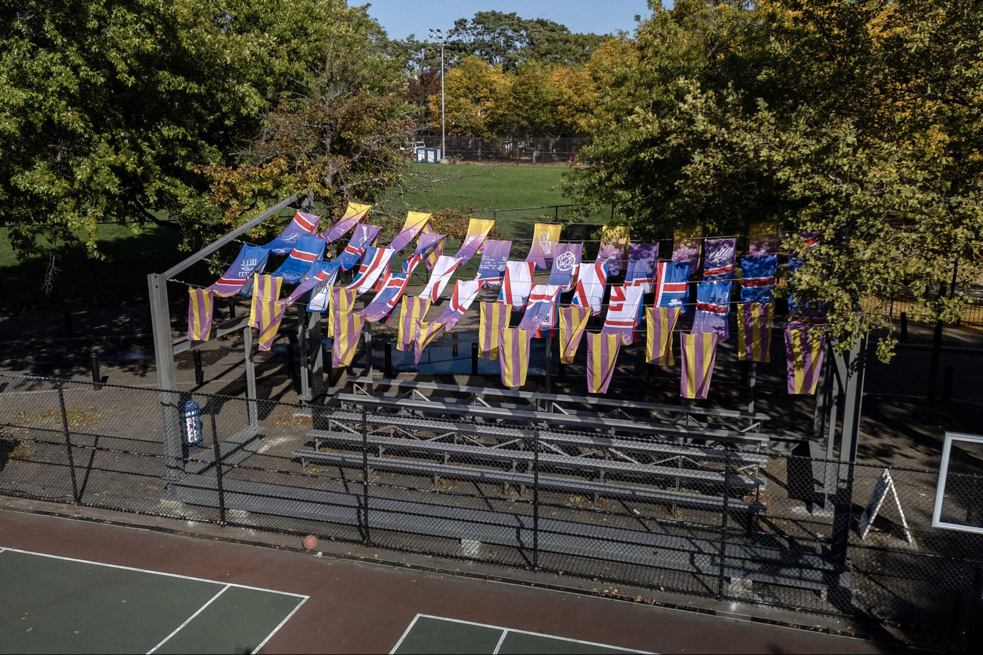 Flags hang from a structure of steel beams and wires to complete Justin Brazier's "A Little Cooler" in Cambridge's Hoyt Park. (Robin Lubbock/WBUR)