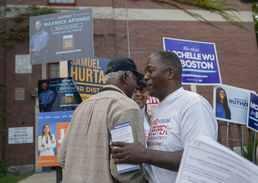 Rev. Miniard Culpepper, candidate for District 7 city councilor, greets voters at the Higginson-Lewis K-8 School in Boston’s Ward 12 on Sept. 9. (Amanda Sabga for WBUR)