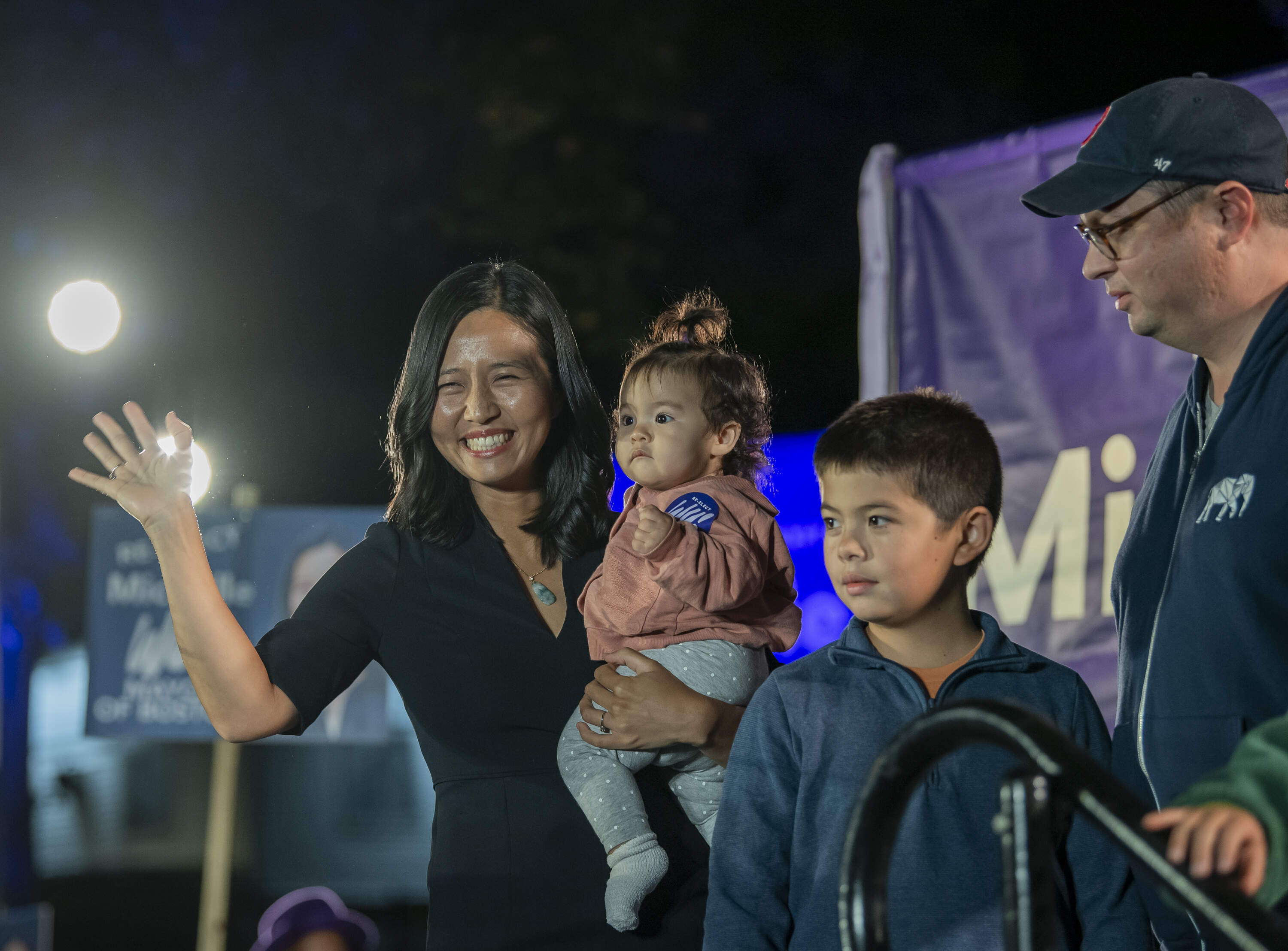 Mayor Michelle Wu and her family after addressing a supporters at her preliminary election night event at Adams Park in Roslindale. (Amanda Sabga for WBUR)