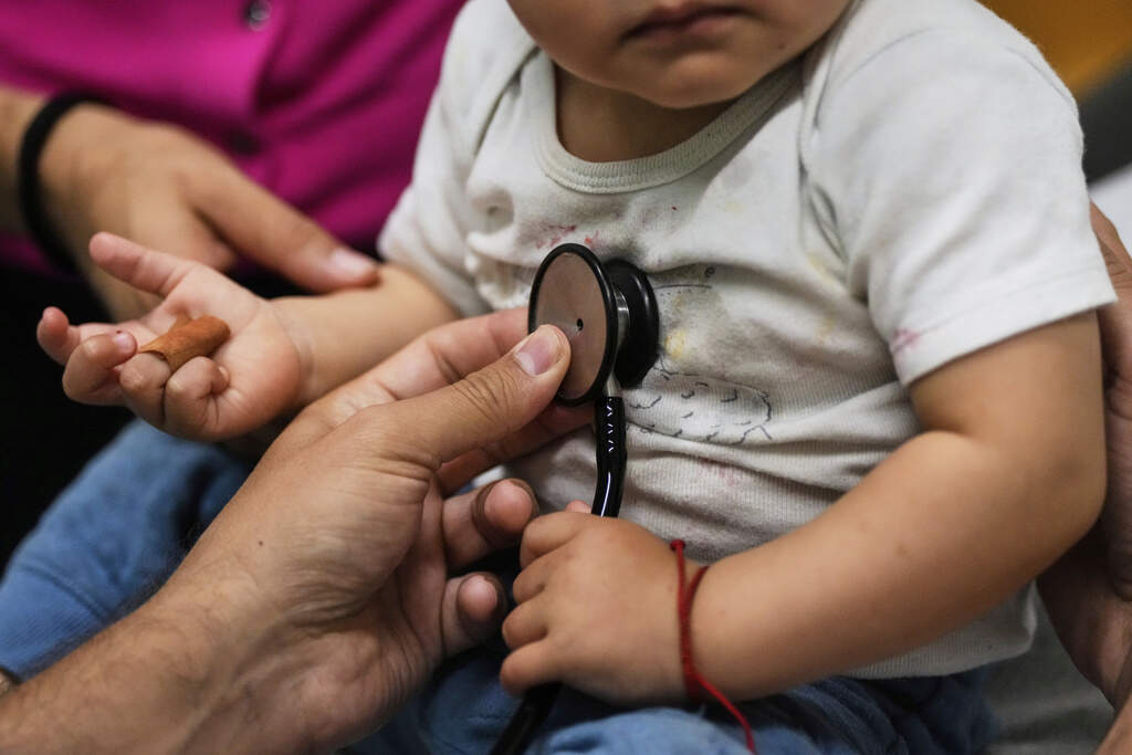 Pediatrician Irving Phillips examines a 16-month-old boy at a CommuniCARE+OLE clinic on June 26 in Davis, Calif. (Godofredo A. Vásquez/AP)