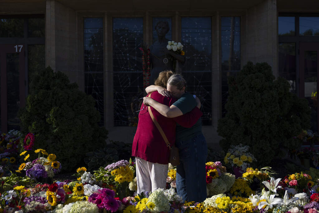 Two women embrace at the memorial outside the Annunciation Catholic Church in Minneapolis following a shooting at the school on August 27. (Ellen Schmidt/AP)