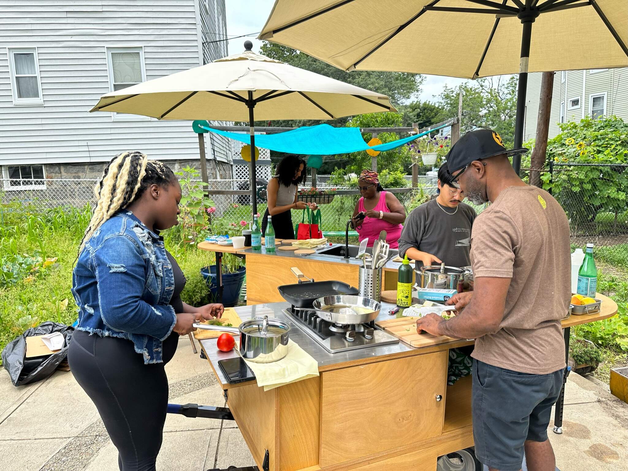 A cooking demo with chef and designer CJ Valerus (right) at the Woolson Street Community Garden in Mattapan. (Courtesy AGONY)