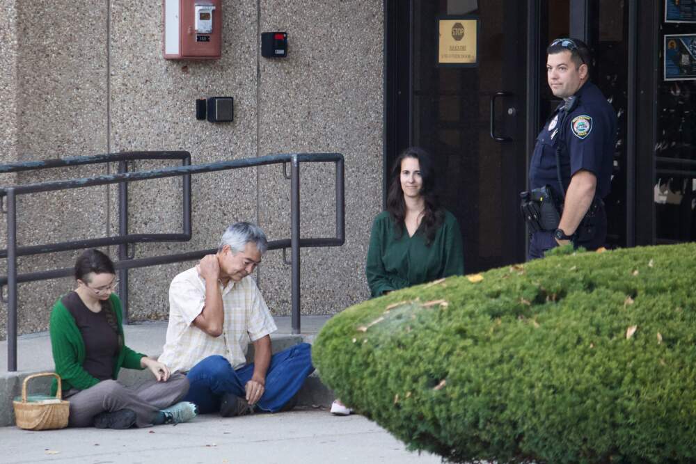 Eleanor Reid, Nathan Phillips and Nastasia Lawton-Stickler went to the Burlington ICE facility to deliver food to immigrants behind held inside. (Miriam Wasser/WBUR)
