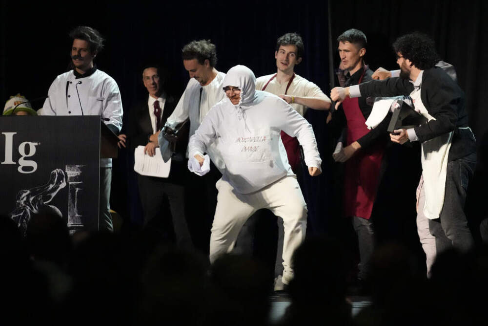 The Ig Nobel Prize for nutrition is accepted by Daniele Dendi, Gabriel H. Segniagbeto, Roger Meek, and Luca Luiselli, for studying the extent to which a certain kind of lizard chooses to eat certain kinds of pizza. (Robert F. Bukaty/AP)